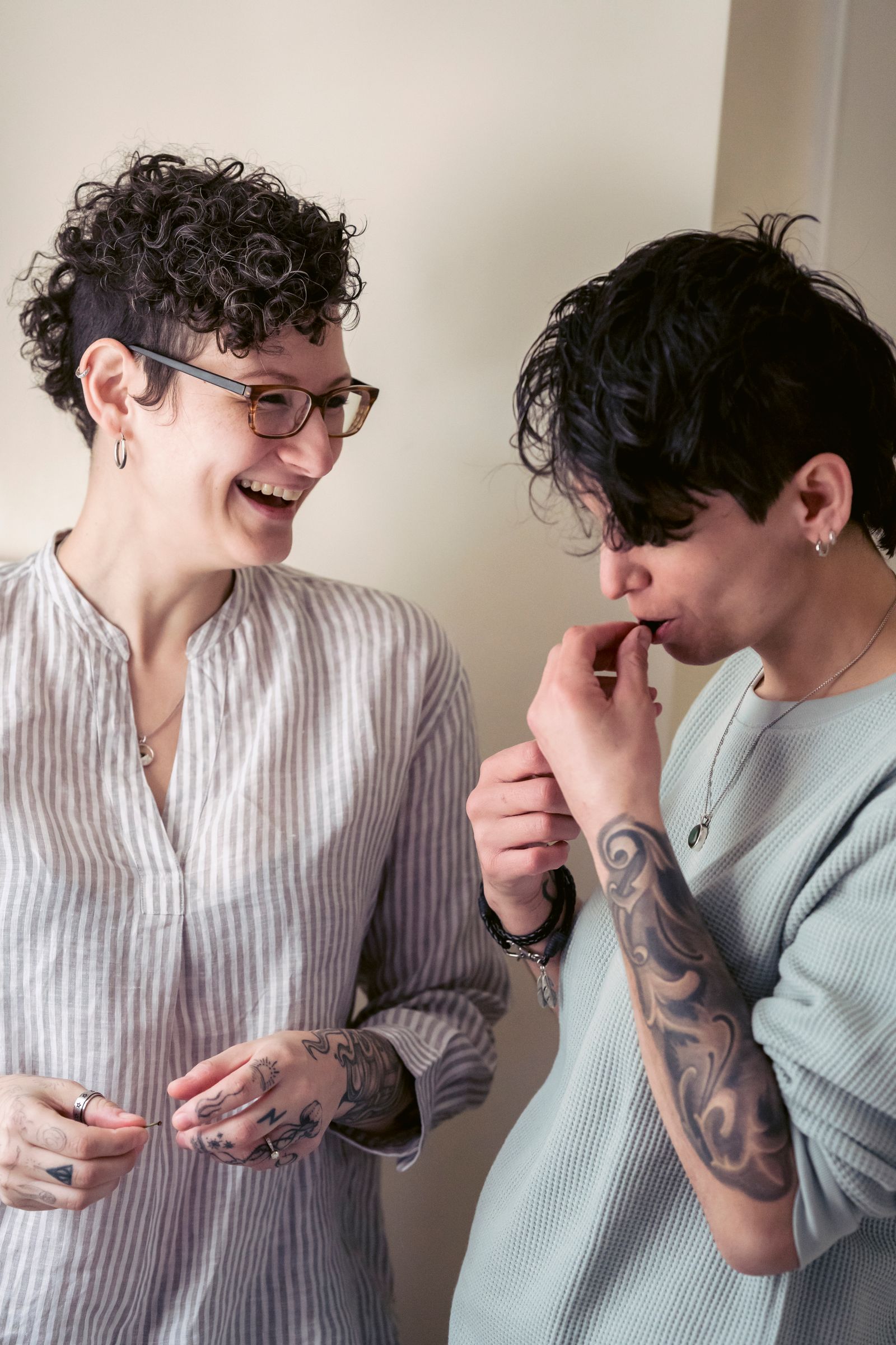 Deux amies riant naturellement ensemble dans un intérieur chaleureux