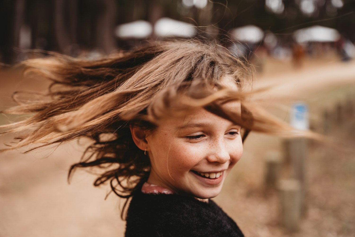 Petite fille qui rit les cheveux au vent dehors