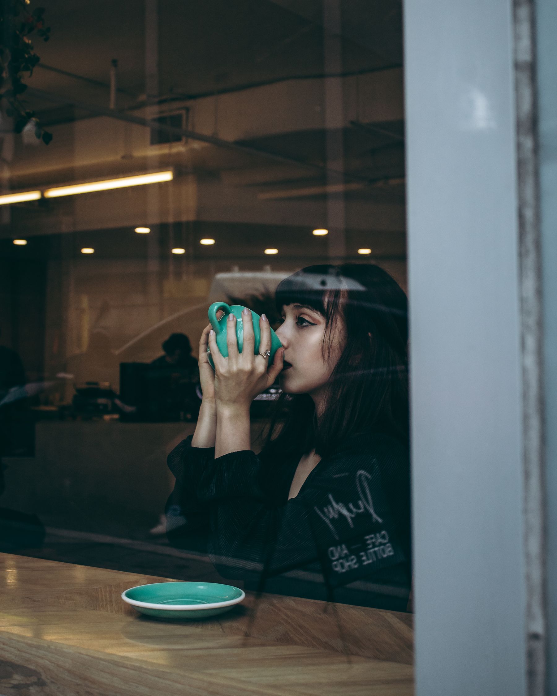 Femme prenant un temps calme près d'une fenêtre pour canaliser ses pensées négatives