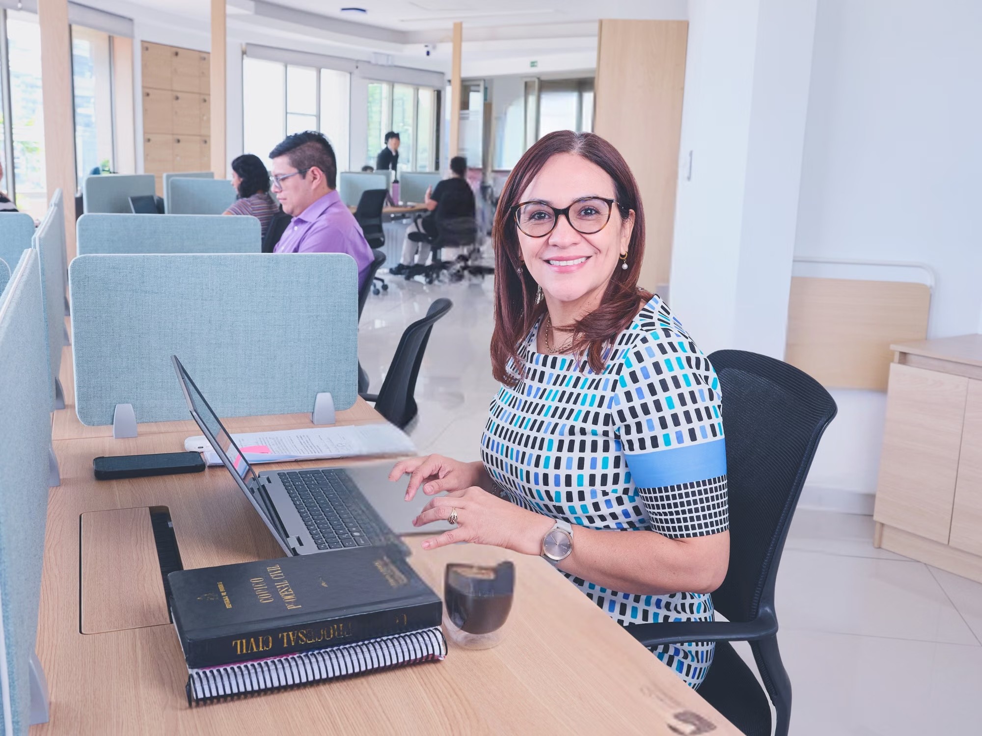 Femme souriante à son bureau après avoir distingué sa valeur de sa performance