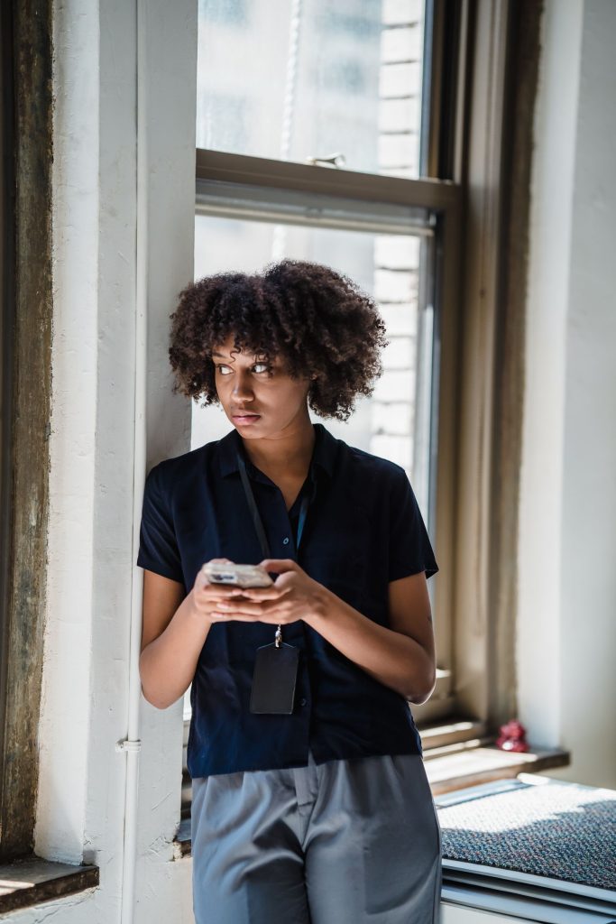 Femme consultant son téléphone près d’une fenêtre après un silence inattendu