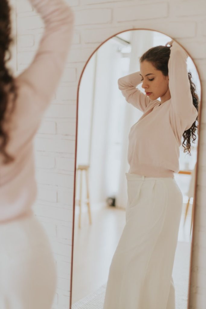 Femme observant son reflet, image du manque d’estime de soi