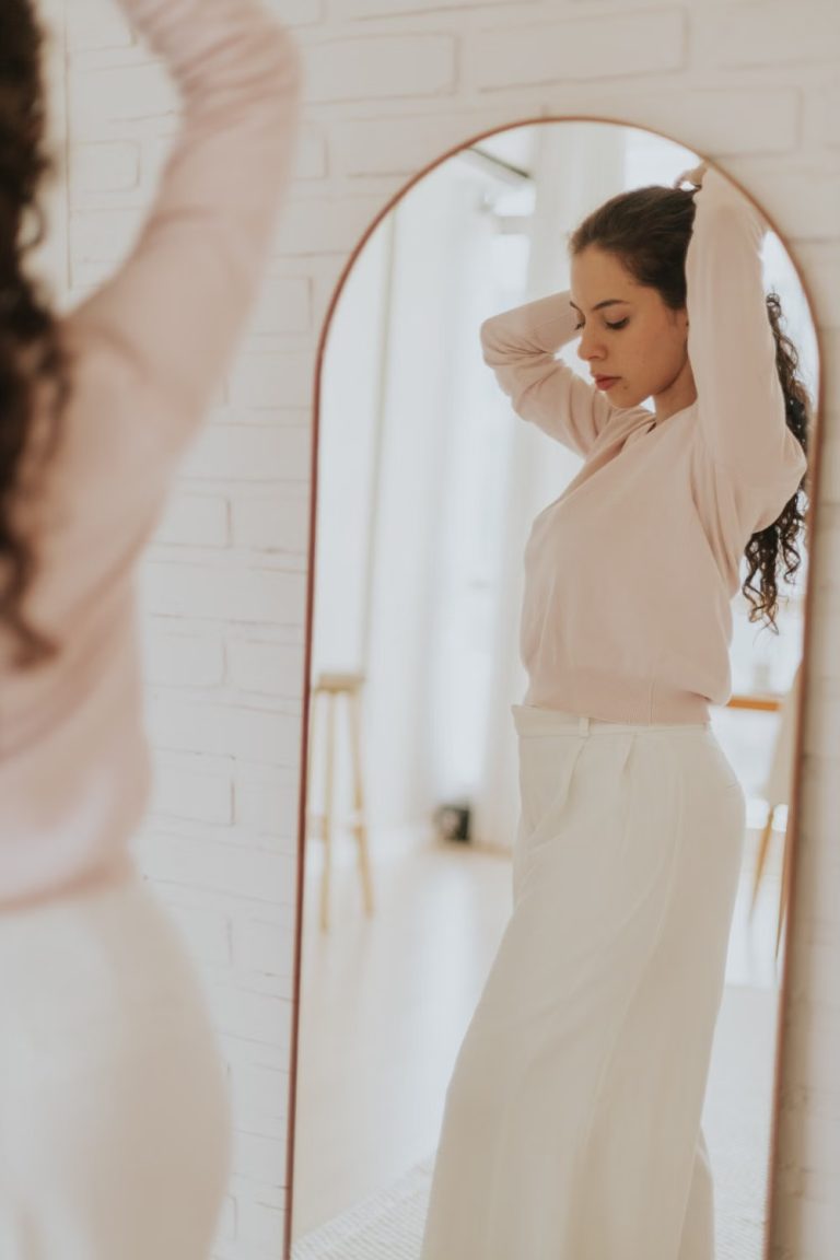 Femme observant son reflet, image du manque d’estime de soi