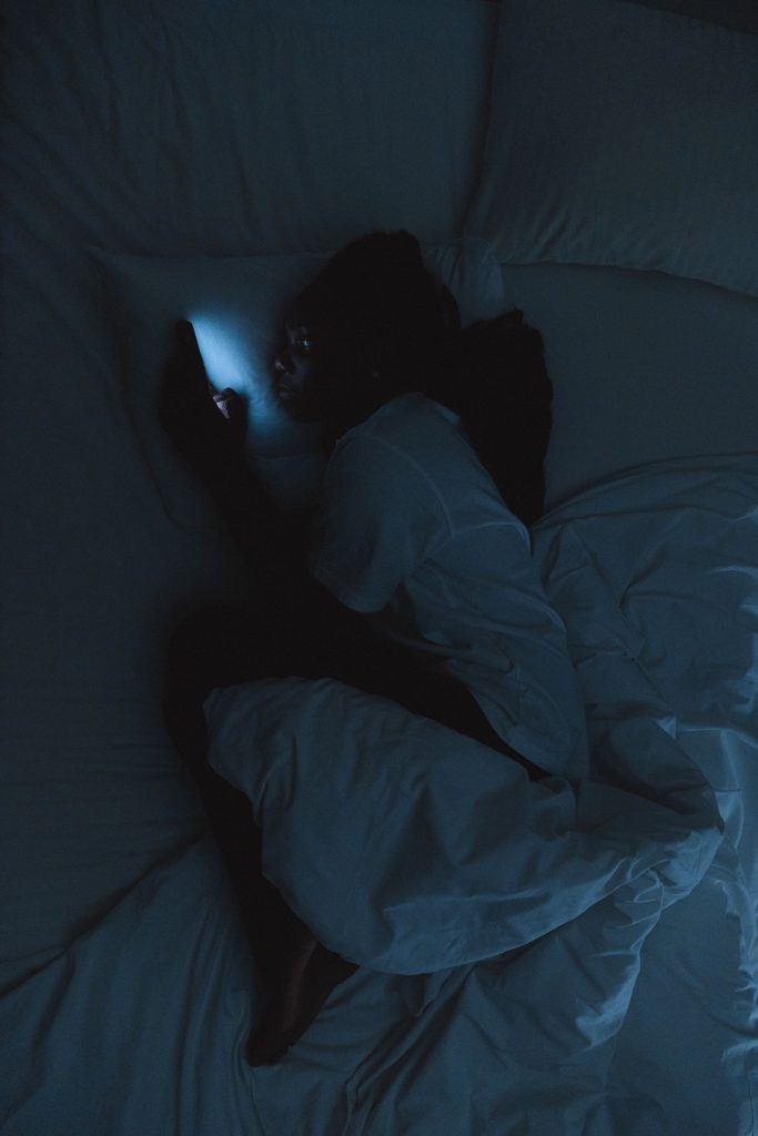 Femme éveillée la nuit se demandant pourquoi elle pense toujours au pire