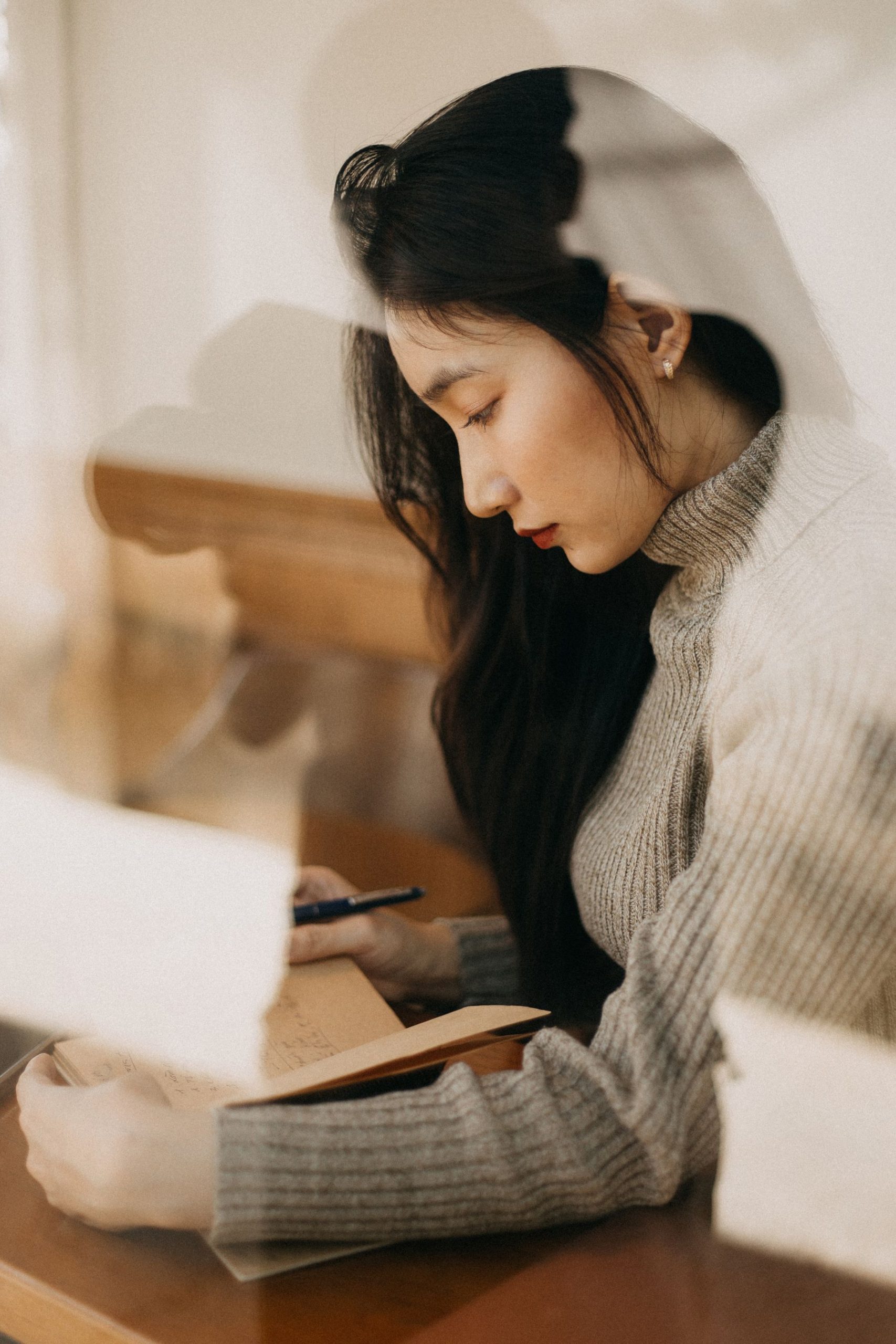 Femme écrivant dans un journal pour distinguer les faits de ses pensées négatives