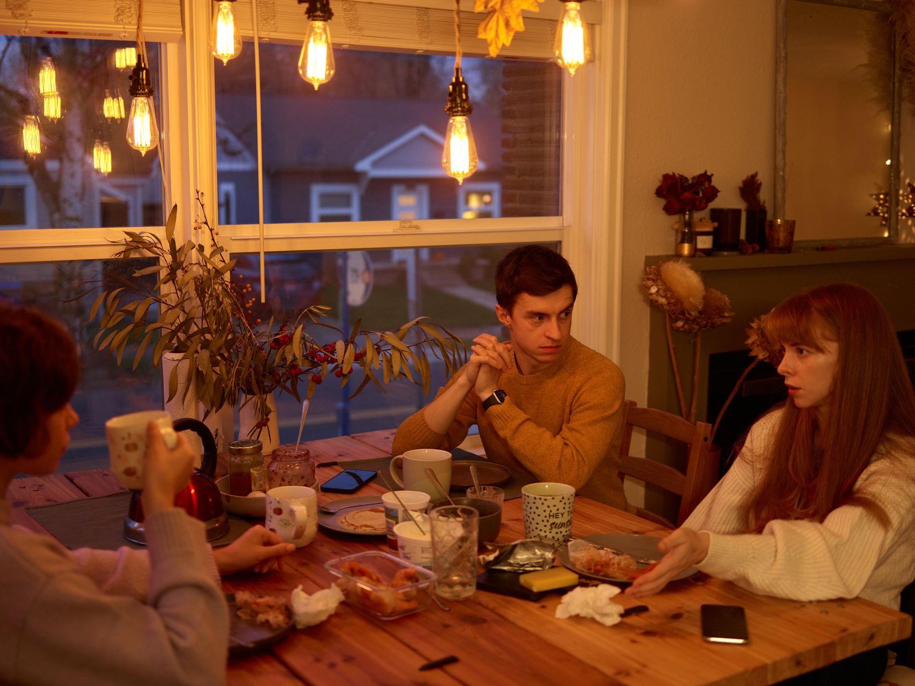 Adultes discutant autour d'une table lors d'un repas de famille