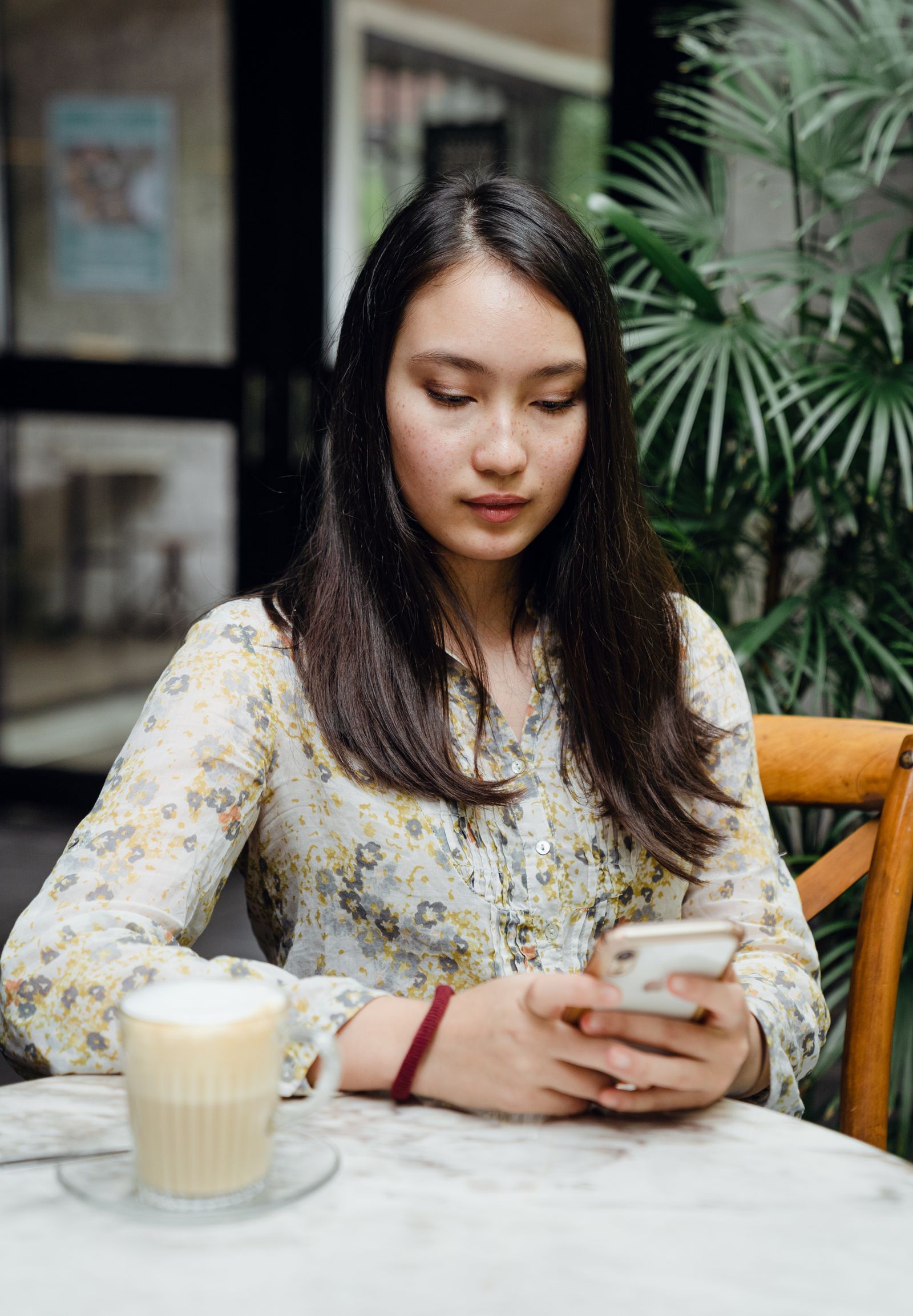 Femme écrivant un message d'invitation depuis un café
