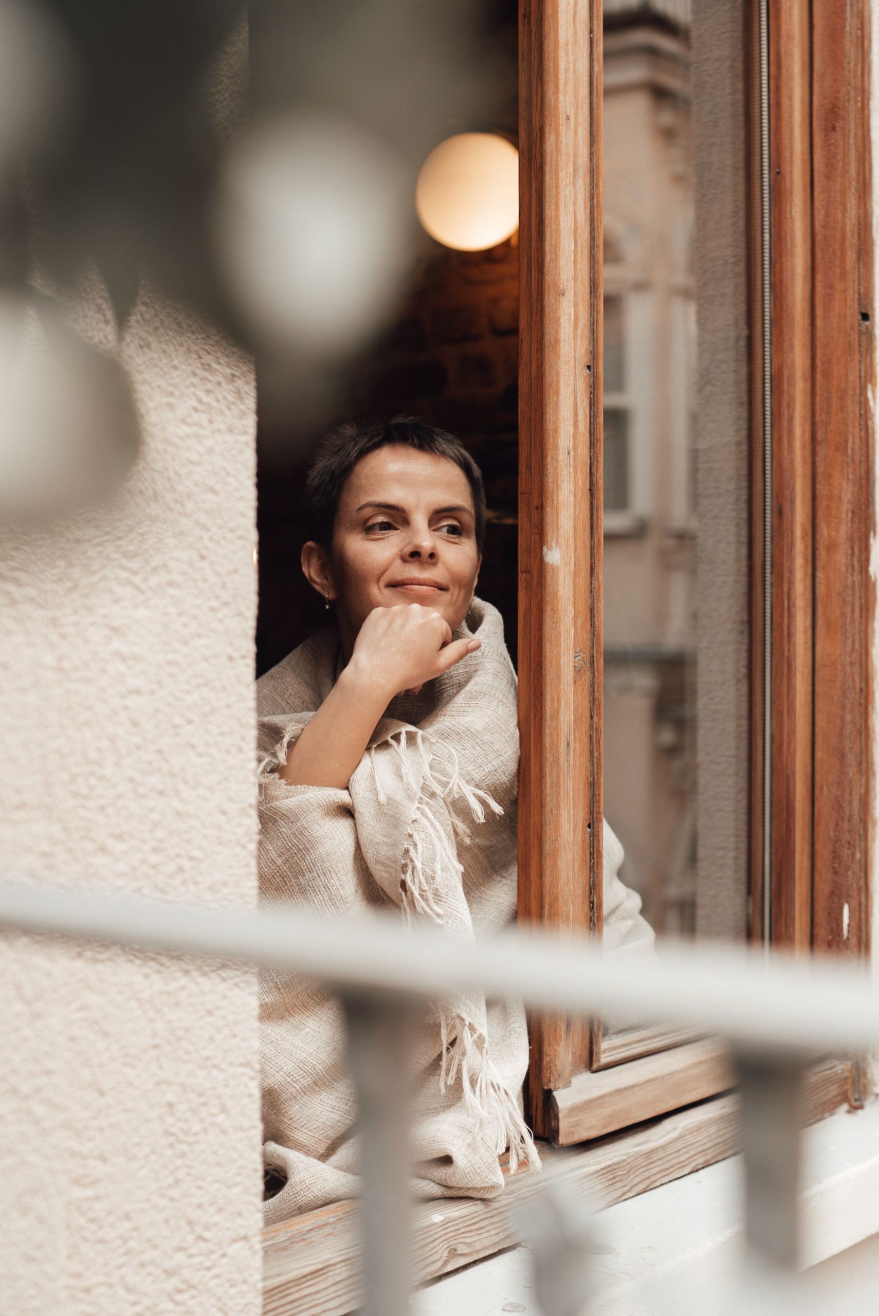 Femme regardant par la fenêtre et se demandant pourquoi elle pense toujours au pire