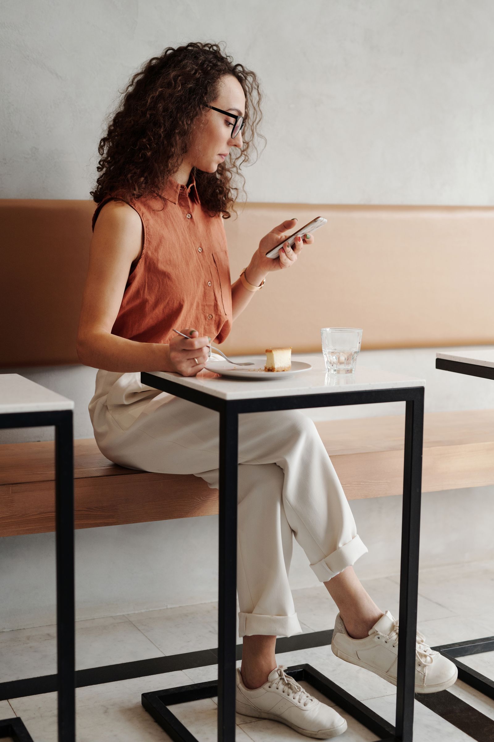 Femme regardant son téléphone dans un café avant d’envoyer un message