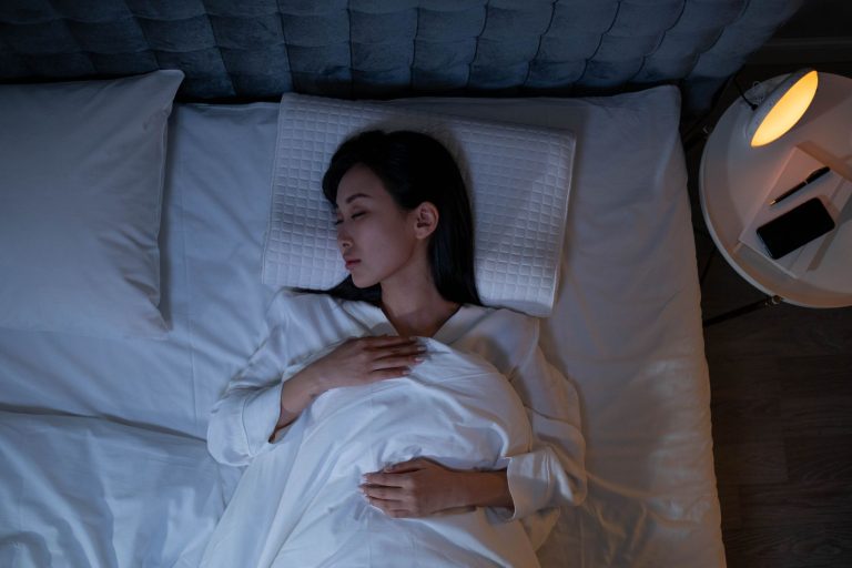 Une femme dort dans une chambre faiblement éclairée malgré les bruits extérieurs